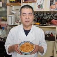 名物のカツ丼を手に持つ５代目の邦之さん＝香取市
