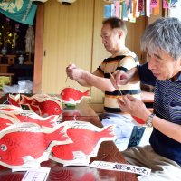 鯛ちょうちんに持ち手の竹を付ける氏子ら
