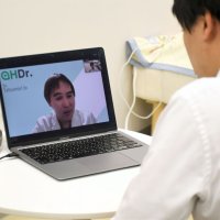 成田空港で医師によるオンライン相談を受ける実演をするスタッフ＝６日、成田市
