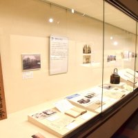 被災者を無料で治療することを知らせる木の看板など、震災に関する貴重な資料が並ぶ企画展＝館山市