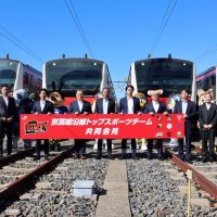発表会見後、京葉線の車両前でポーズを取る土沢ＪＲ千葉支社長（左から４人目）とチーム代表者ら＝２５日午前、千葉市美浜区