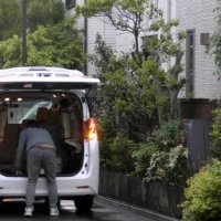 東京都内で車から客の荷物を下ろす陳容疑者＝４月２３日午後５時半ごろ（千葉県警提供）