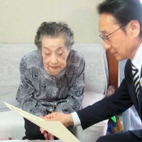 祝い状を読み上げる田中市長（右）と磯部さん＝１６日、市川市