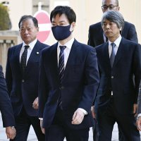 東京地裁に入る秋本真利被告（手前）＝２５日午前（代表撮影）（共同）
