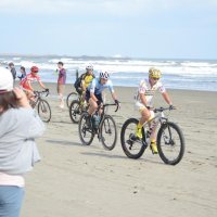 砂浜を自転車で周回するスポーツ「ビーチクロス」で、九十九里浜を走る選手ら＝１０月１４日、九十九里町
