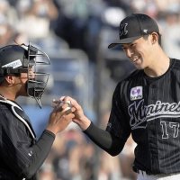 プロ野球史上１６人目となる完全試合を達成し、捕手の松川（左）からボールを受け取る佐々木朗希＝２０２２年４月、ＺＯＺＯマリン（共同）