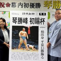 自身の幕内初優勝を報じた号外のパネルを掲げる琴勝峰関（右）＝１日、柏市