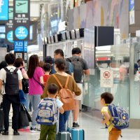 国際線に搭乗するために多くの旅客が保安検査場の列に並ぶ成田空港＝８日午後、成田市