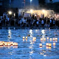 勝浦市の興津海水浴場で１４日夕、先祖を供養する夏の風物詩「灯籠流し」が営まれた。参加した地域住民らは、ほのかな光を放ち流れる約４００基の灯籠を静かに見つめ、手を合わせた
