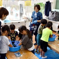 神崎町の職員らに教わりながら藍染めに挑戦する子どもたち＝同町