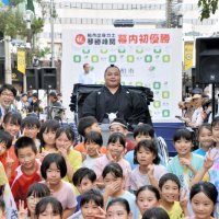 母校の市立松葉第二小の児童と記念撮影する琴勝峰関（中央）＝７日、柏市