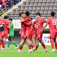 専大松戸を延長戦で下し、チームメートと喜び合う流通経大柏イレブン＝１６日、千葉市のフクダ電子アリーナ