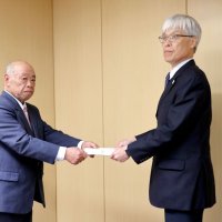 成田空港機能強化の用地確保に向けた提言書をＮＡＡの藤井社長（右）に手渡す石井会長＝２５日、成田市